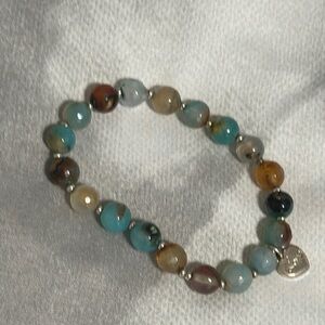 Natural multi stone bracelet with silver heart charm and silver spacers.